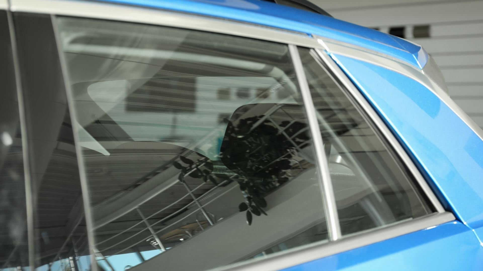 Blue car window with reflections of architectural structures